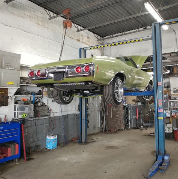 A classic car up on the lift at Frank's